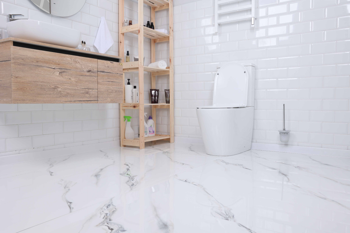 Интерьер ванной комнаты с глянцевым керамогранитом под белый мрамор и деревянной тумбой