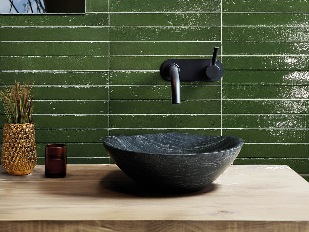Черная раковина на фоне зеленой плитки