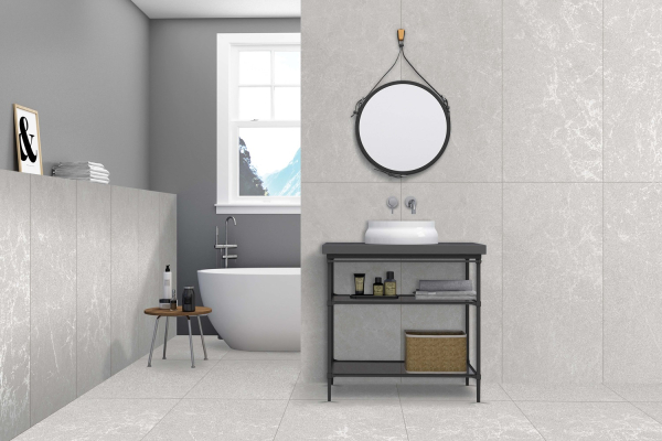 Серая ванная комната с ванной и круглым зеркалом