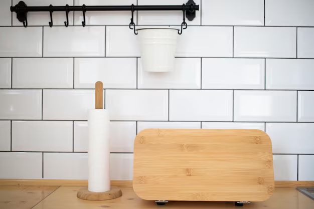 Кухня с белой кирпичной стеной, деревянной разделочной доской и полкой с горшком. Кухонный интерьер с белой кирпичной стеной, на которой висит черная полка с горшком.