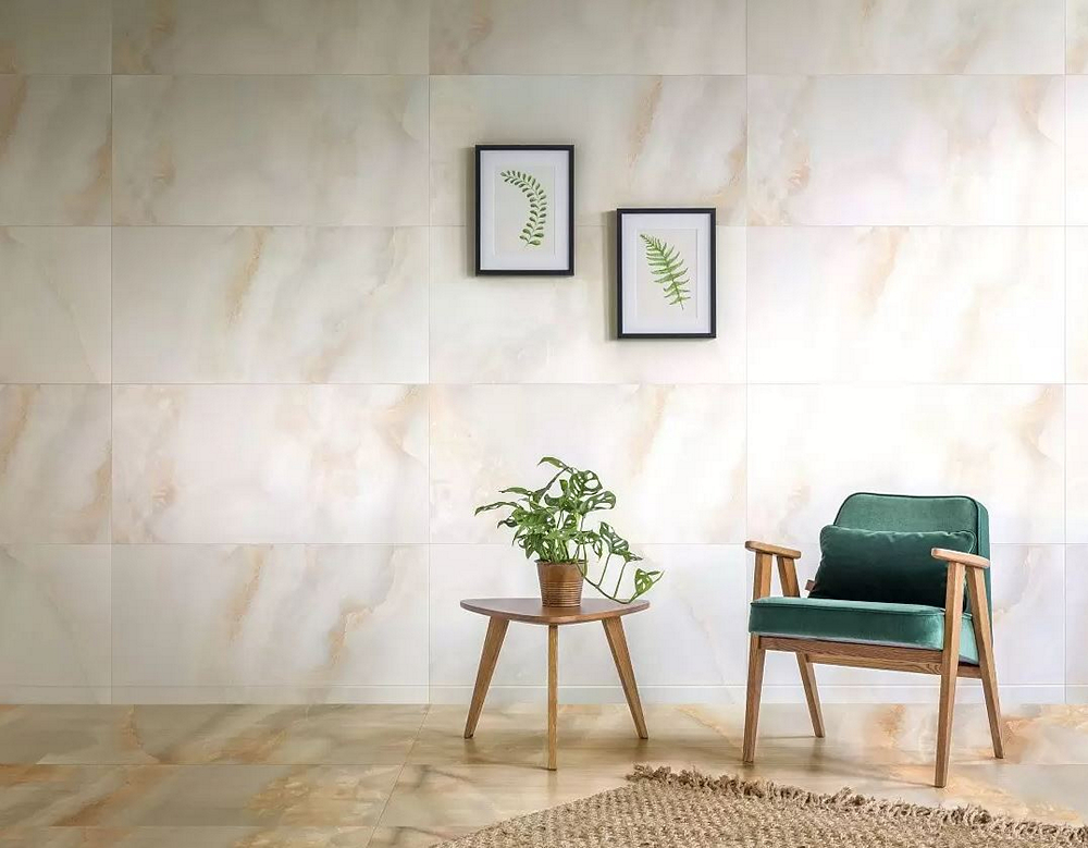 Комната с мраморной плиткой, зеленым креслом и растением.