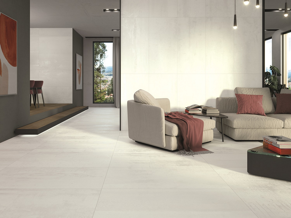 Современная гостиная с минималистичным дизайном Светлый диван с подушками, журнальный столик с книгами и декоративными элементами.